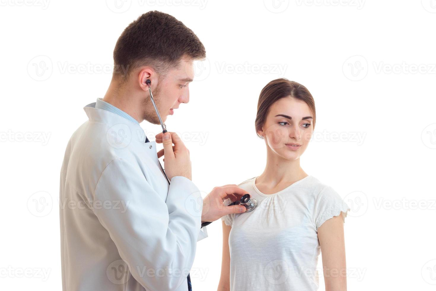 young doctor listens with a stethoscope heart girl close-up photo