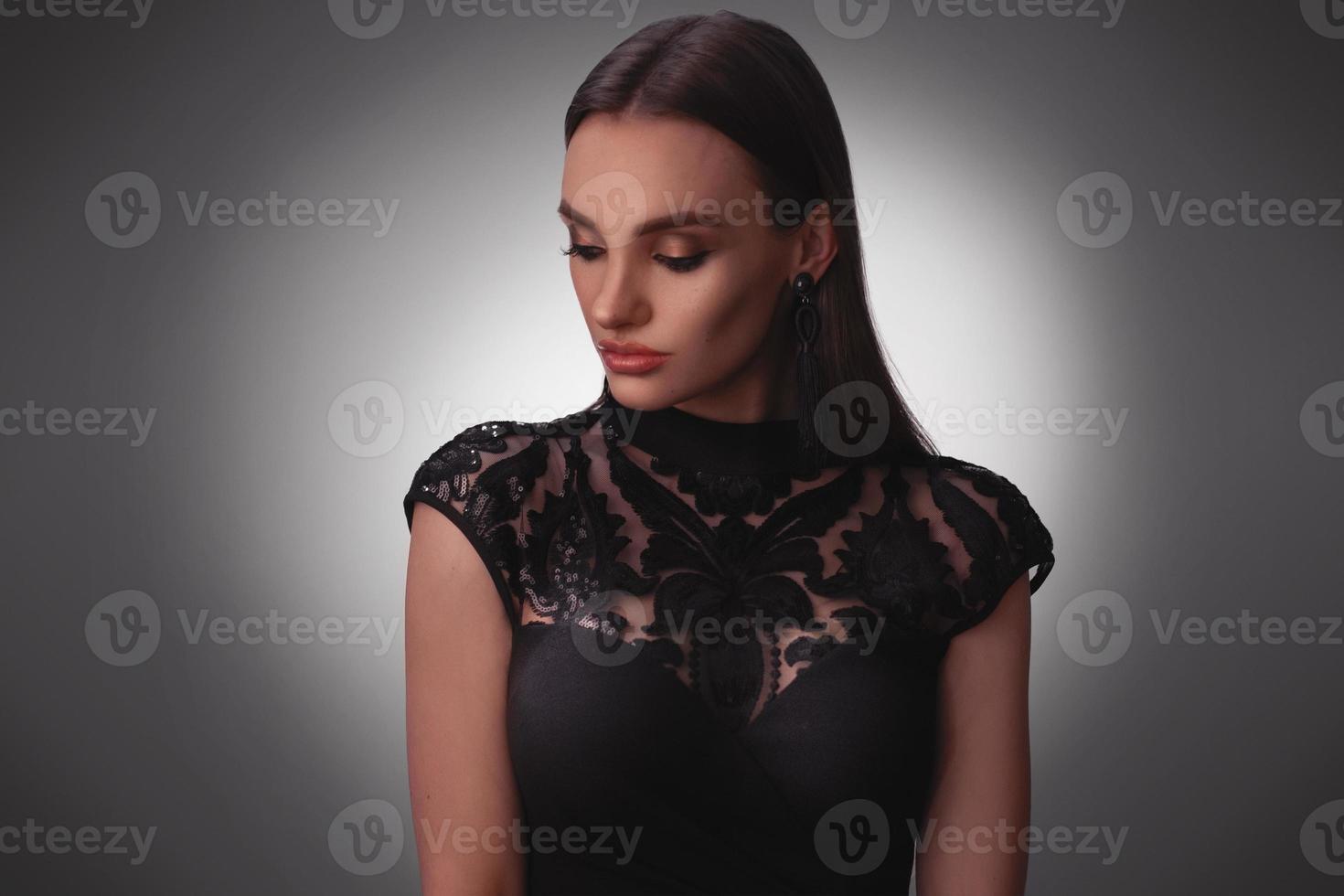 Sexy young lady in black dress in studio photo