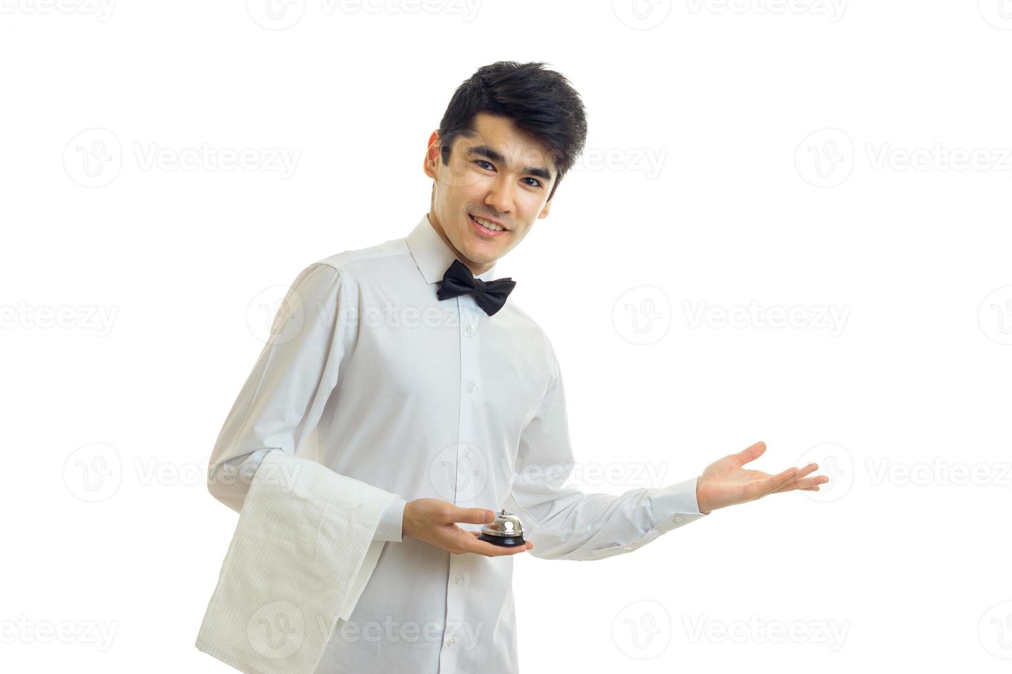 Hermoso moreno camarero de uniforme con corbatín sonriendo a la cámara foto