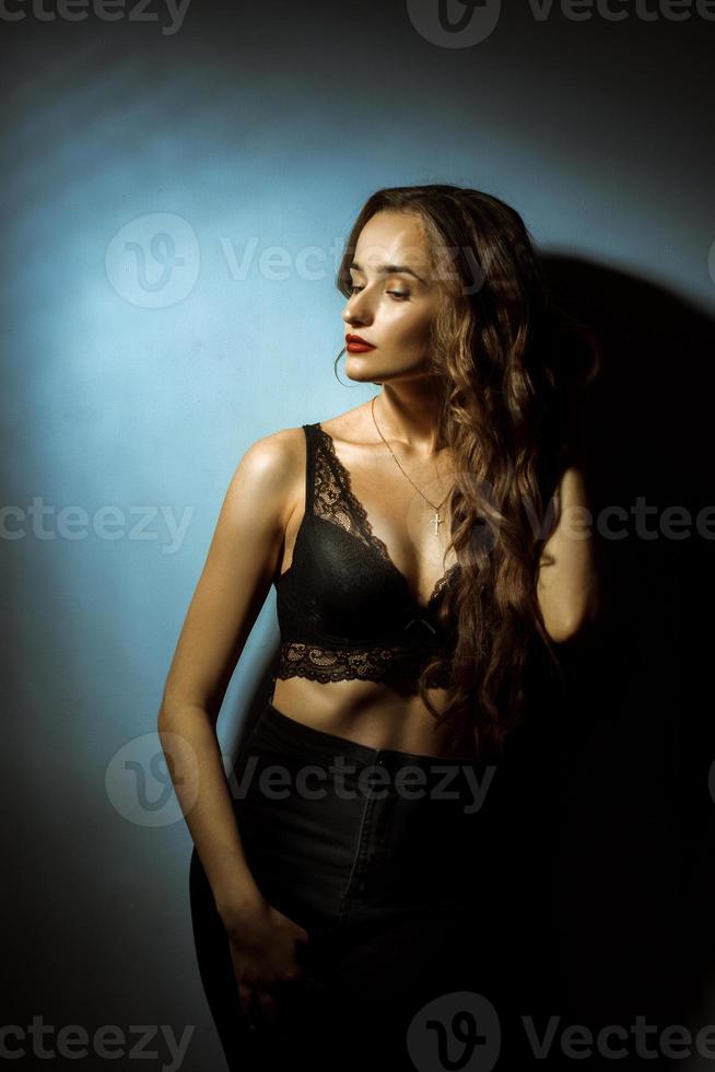 Gorgeous lady with curly hairstyle in dark studio photo