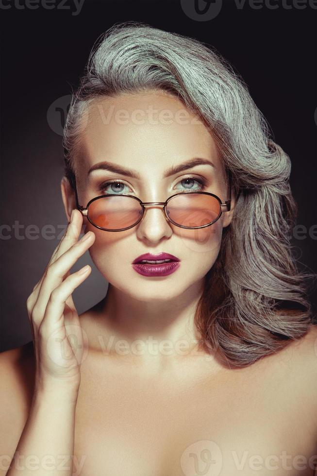 retrato de mujer linda con elegantes gafas de sol con color de pelo gris y buen maquillaje foto
