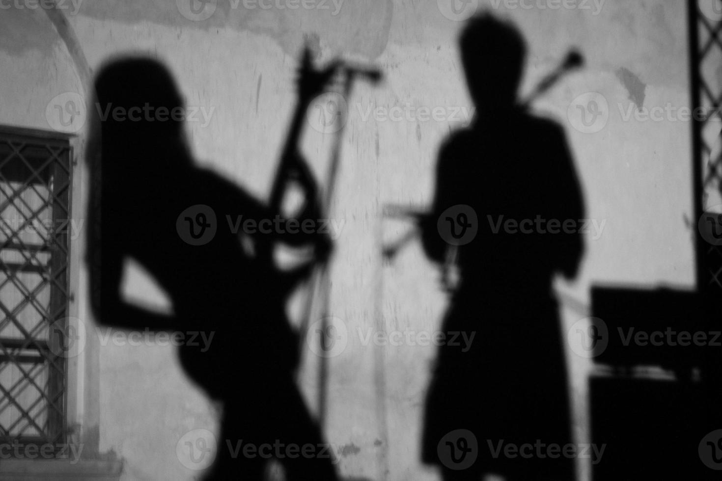 en la pared la sombra de un músico guitarrista durante un concierto. foto
