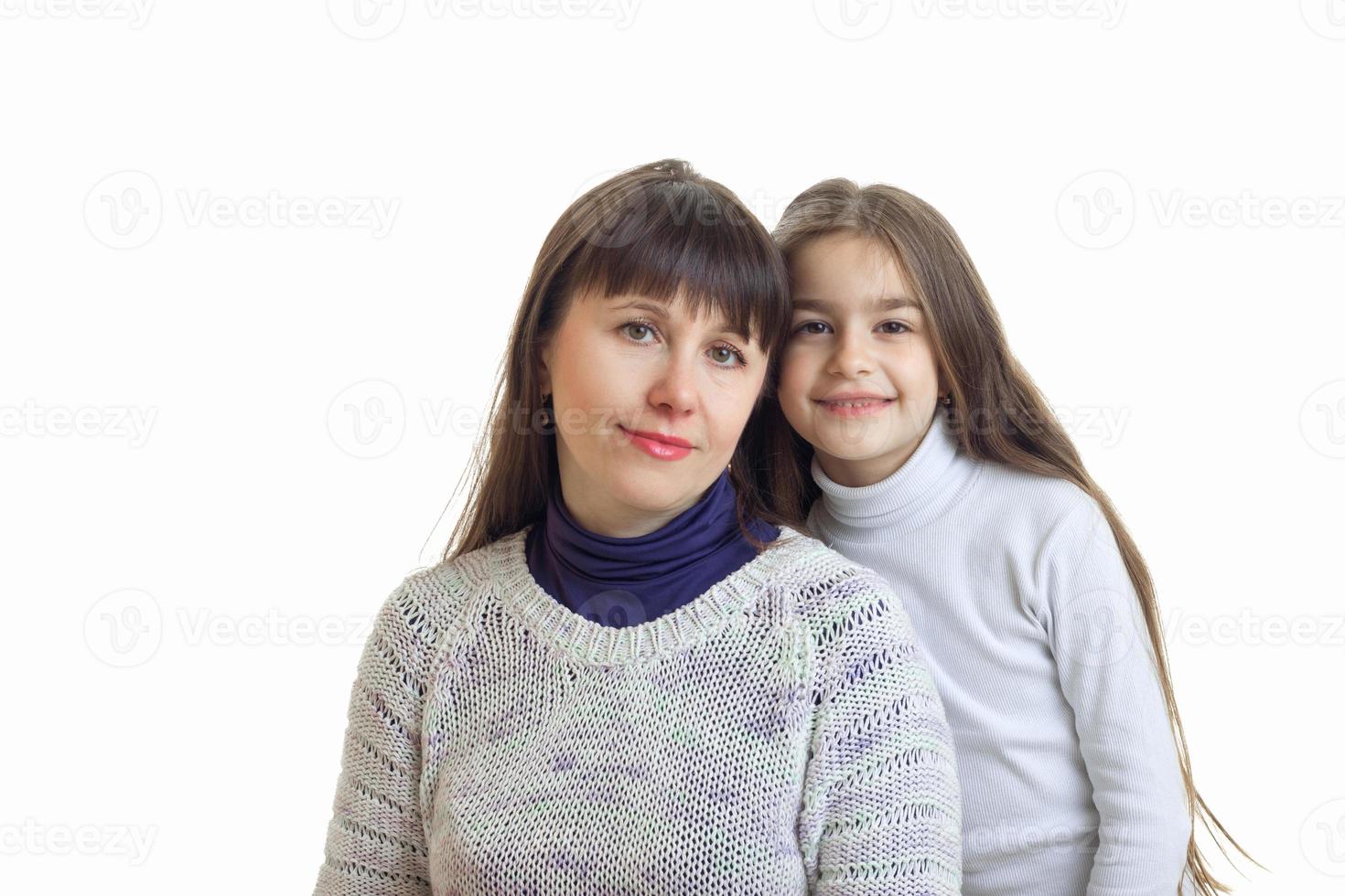 madre con su hija abraza y sonríe en cámara foto