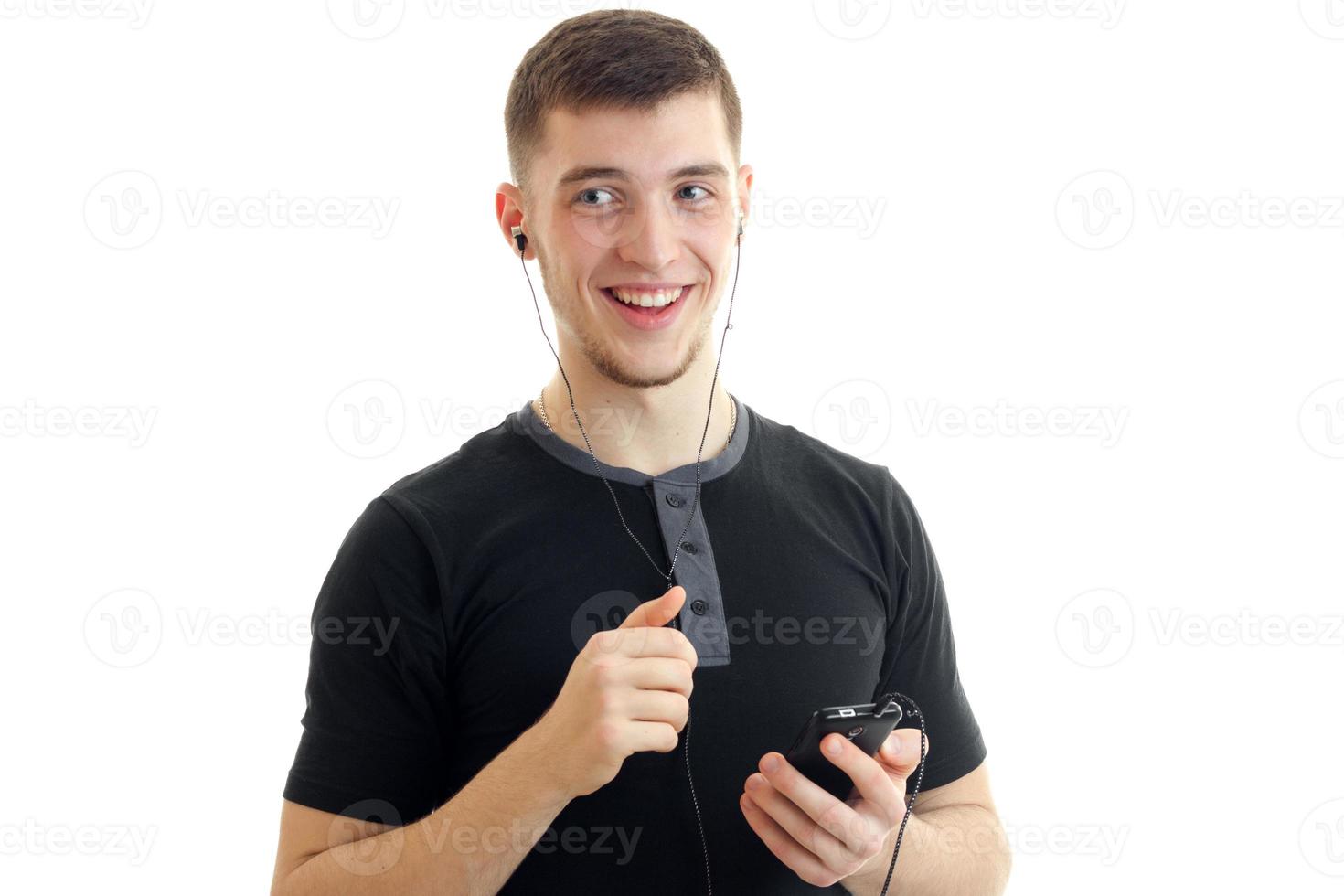 close-up portrait of a handsome guy who smiles and holds phone photo