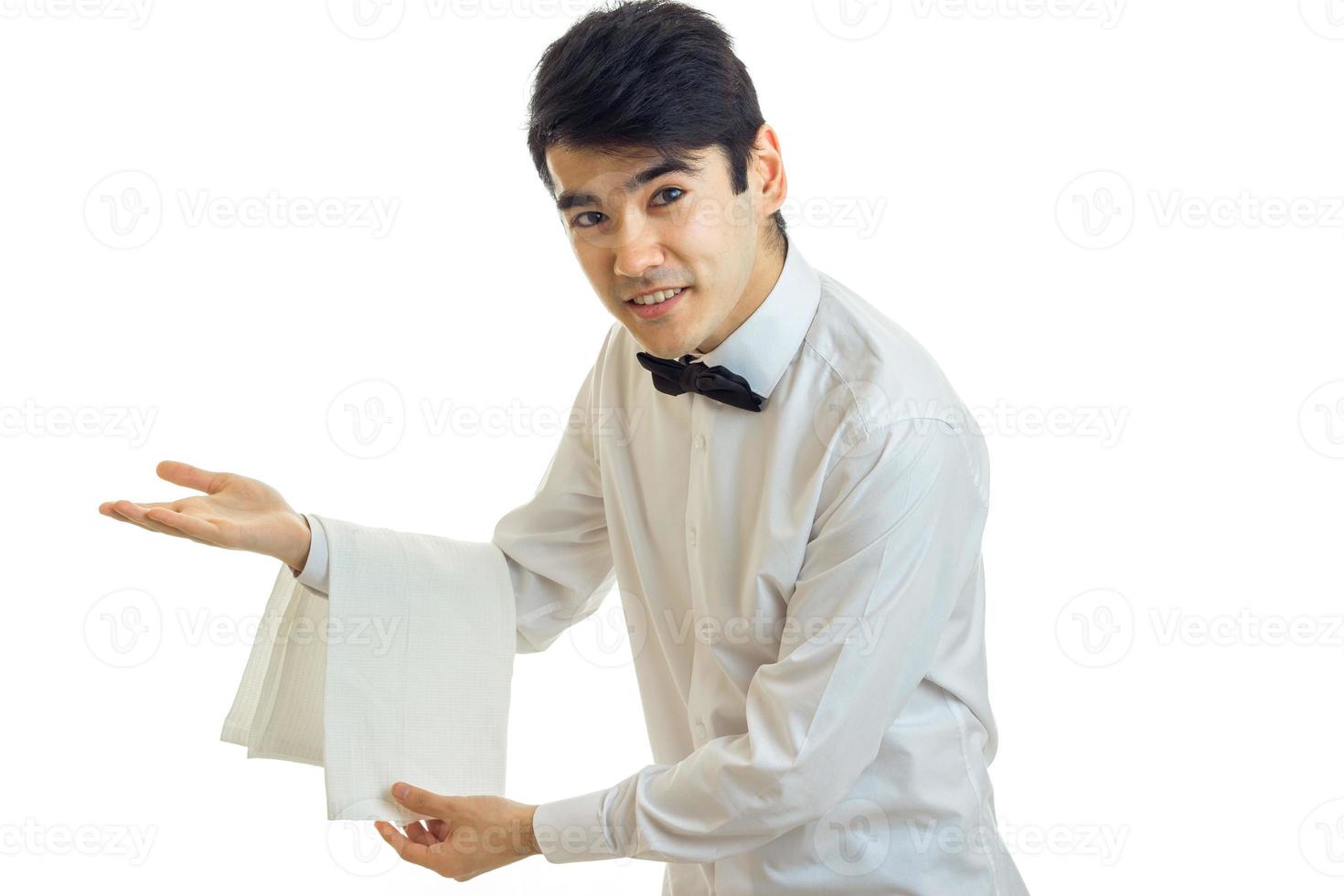 handsome young waiter invites guests to the table and smiling photo