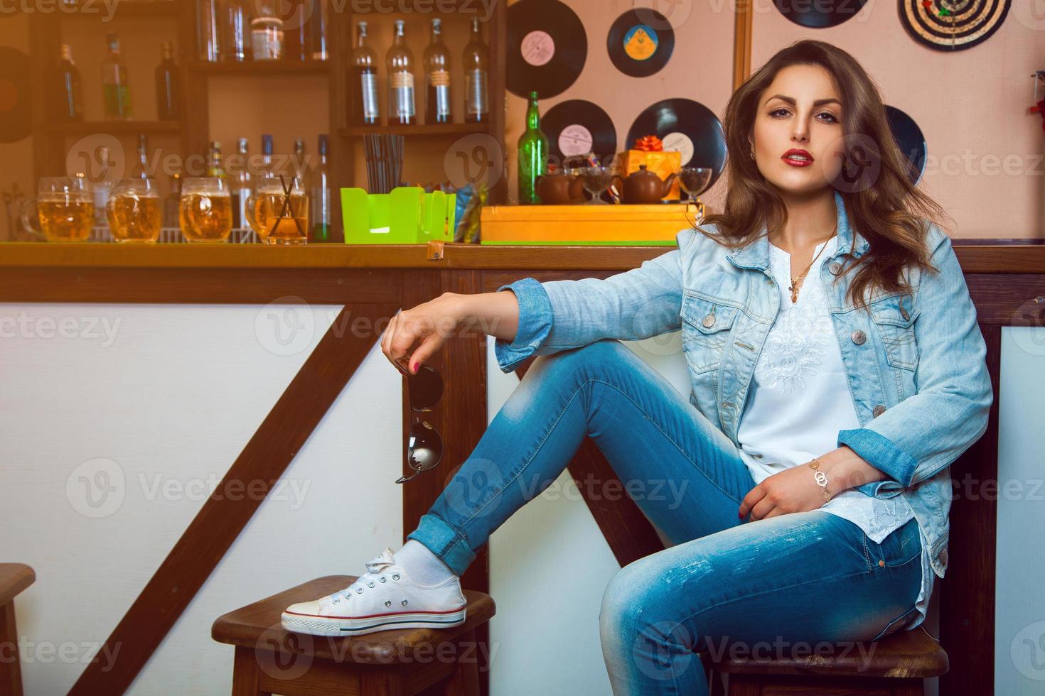 Adorable brunette in casual jeans look behind bar table photo