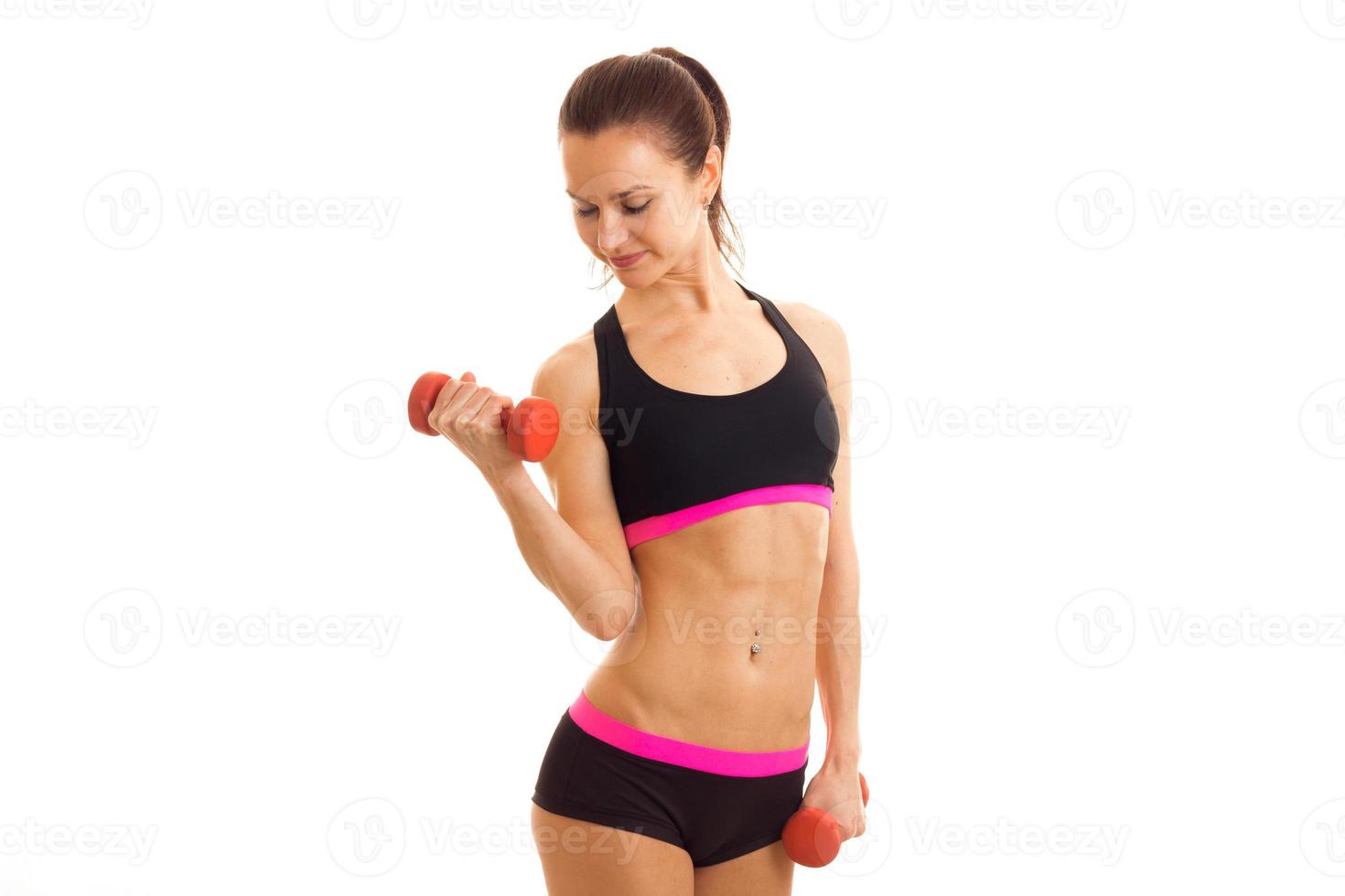beautiful sportswoman at the top looking down smiling and holding a dumbbell photo