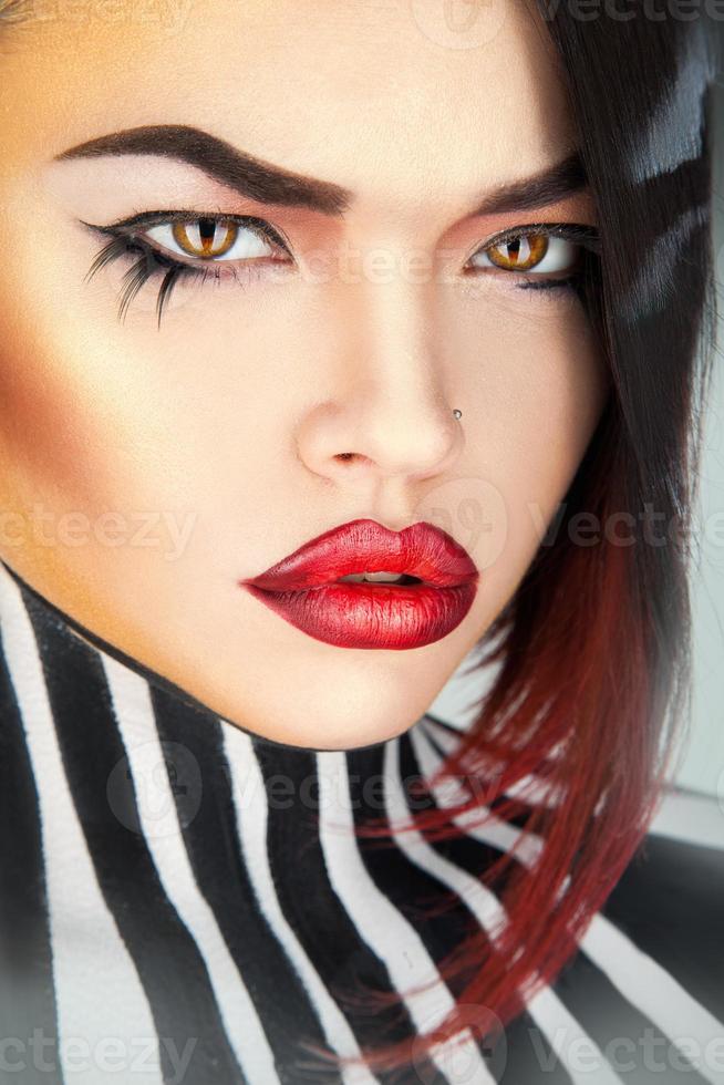 Serious woman with sexy red lips looking at camera photo