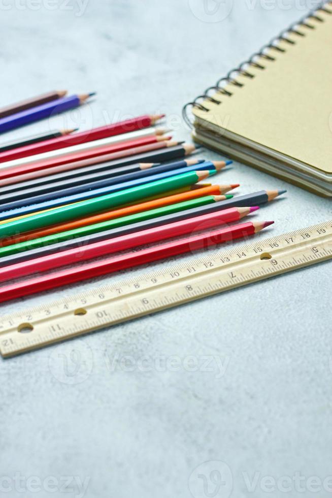 crayones de madera esparcidos sobre la mesa, reglas de madera y cuadernos con el festival de regreso al semestre, los estudiantes van a la escuela, clases de arte. foto