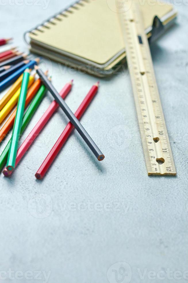 crayones de madera esparcidos sobre la mesa, reglas de madera y cuadernos con el festival de regreso al semestre, los estudiantes van a la escuela, clases de arte. foto