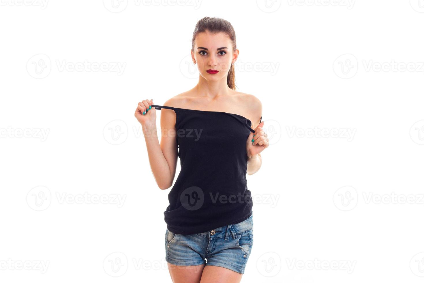 charming pretty girl with red lipstick stands right keeps hand t-shirt on your body and looking at camera photo