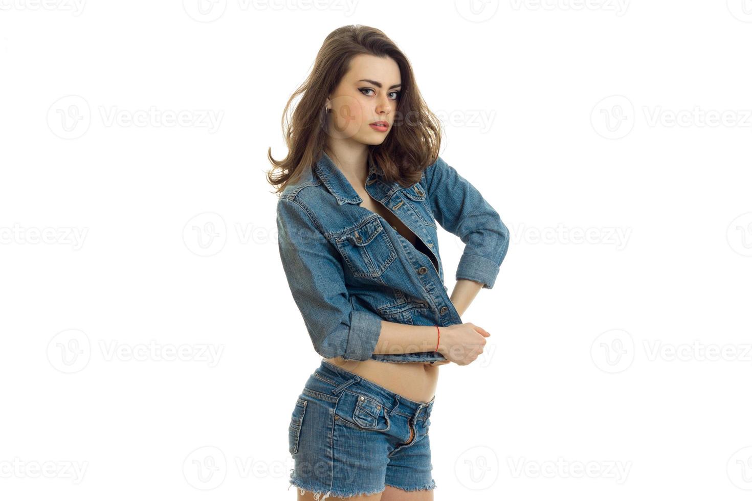 gorgeous young girl in jeans costume sexy looks at camera photo