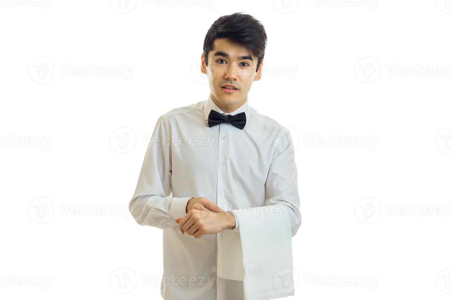 charming young waiter stands upright with cloth on hand photo