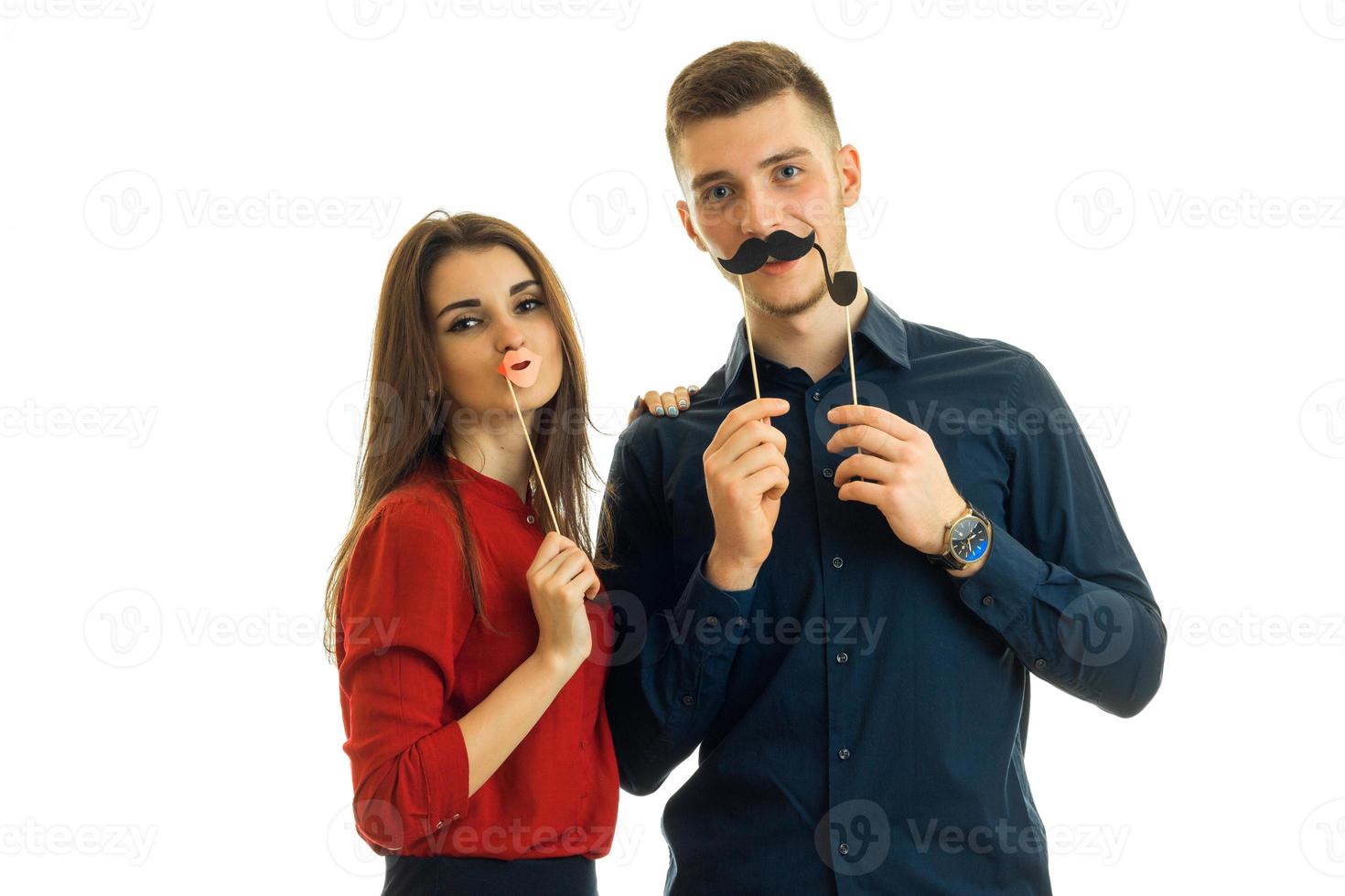 beautiful girl and a young guy hold near face paper Dummies for photo and looking at camera