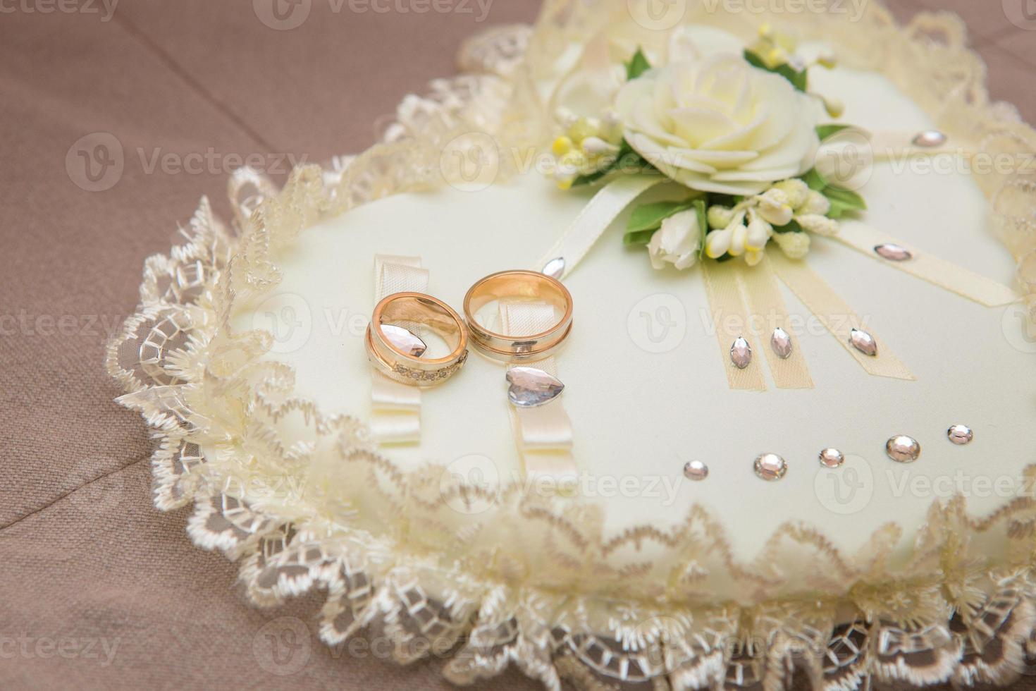 close-up wedding rings lie on a white pillow photo