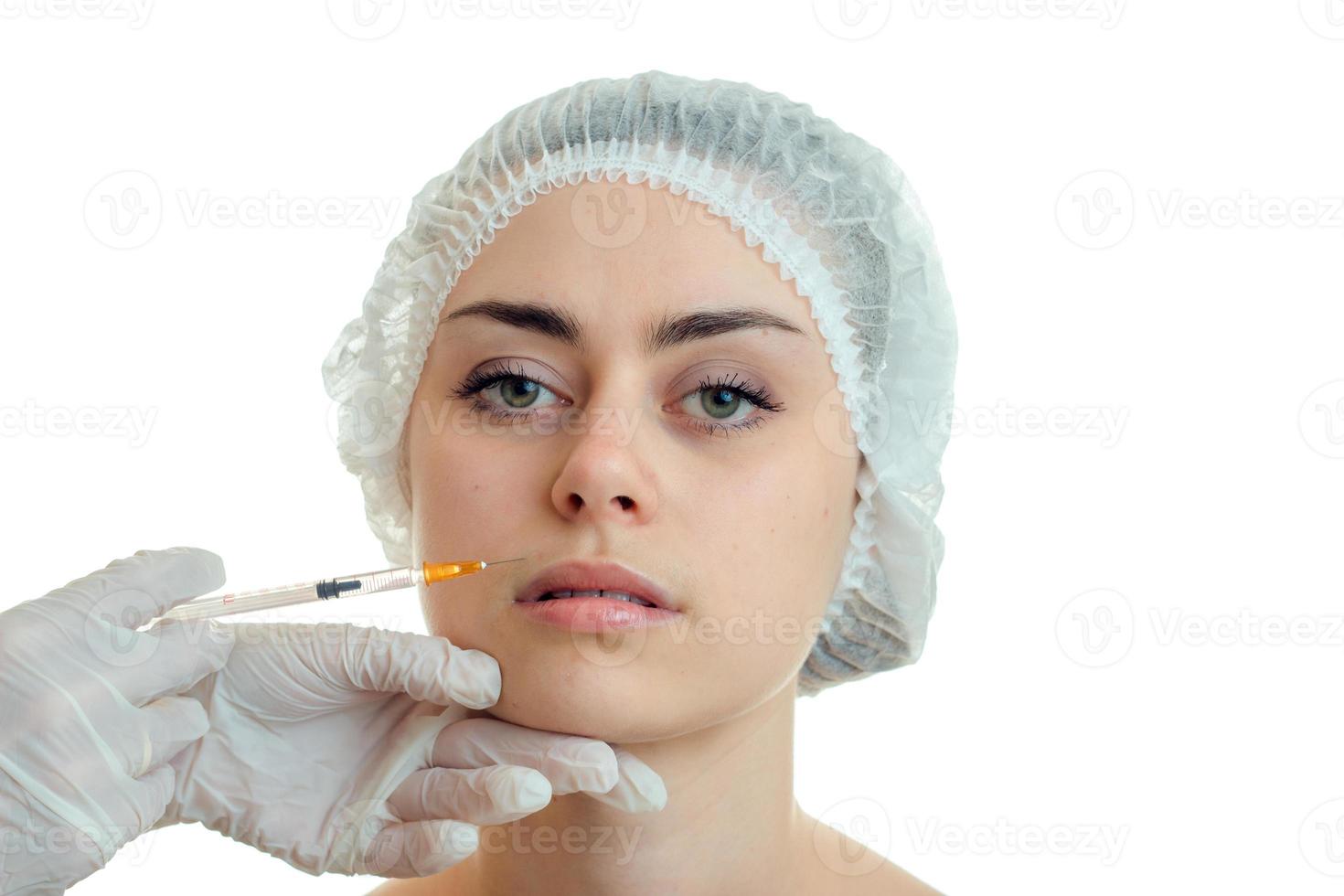 Portrait of a beautiful girl without makeup which cosmetologist doing facial injections photo