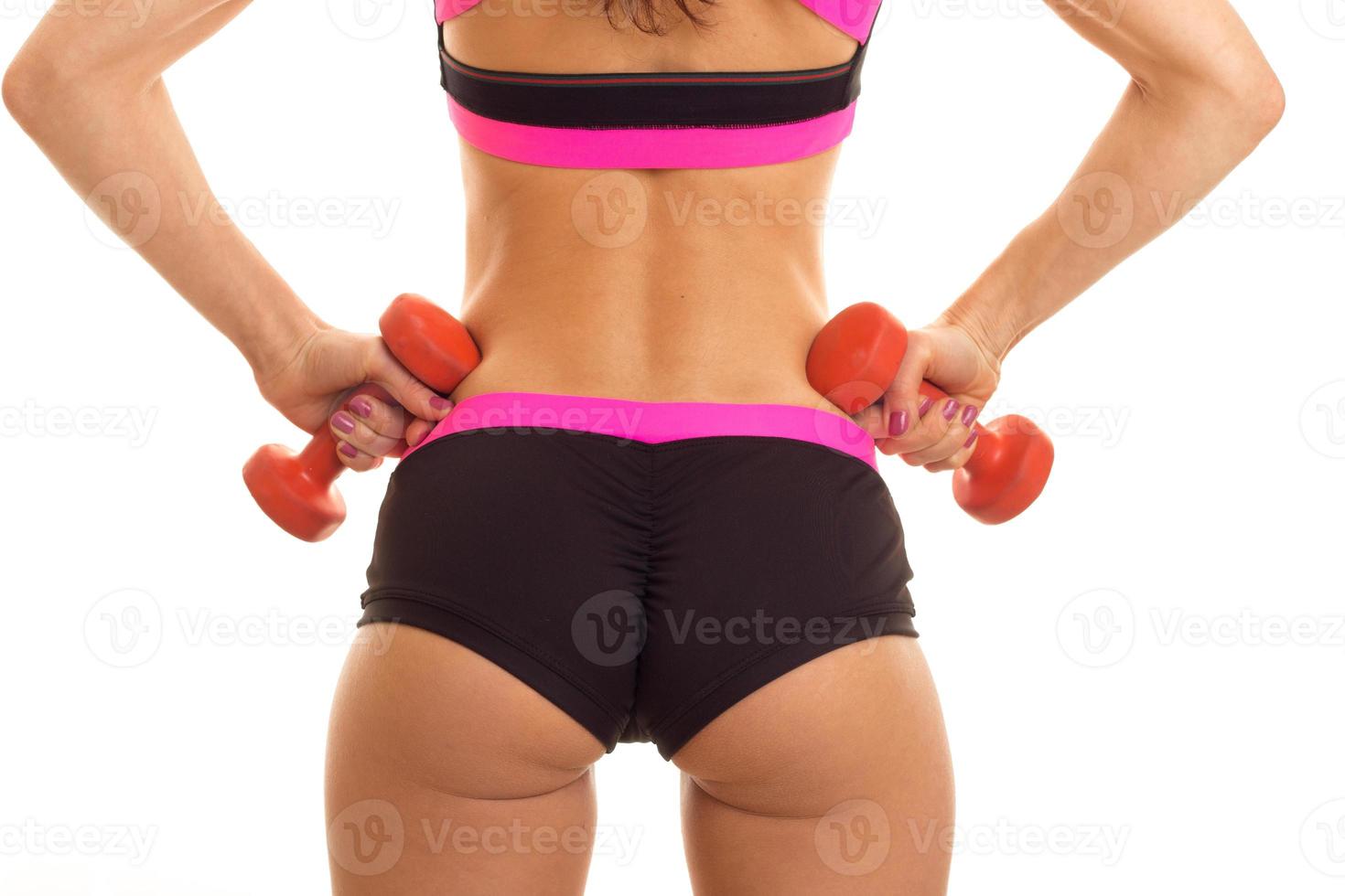 a close-up portrait of women's sports round buttocks in short shorts with dumbbells photo