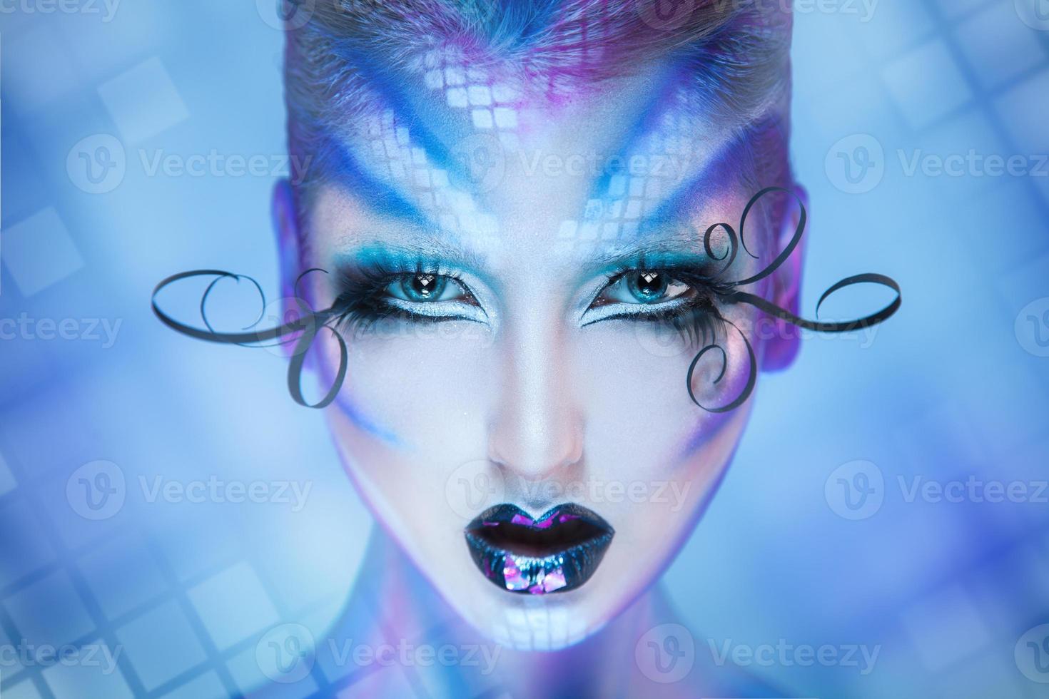 Horizontal portrait of serious adult young female looking at camera with blue eyes and creatiev body art photo