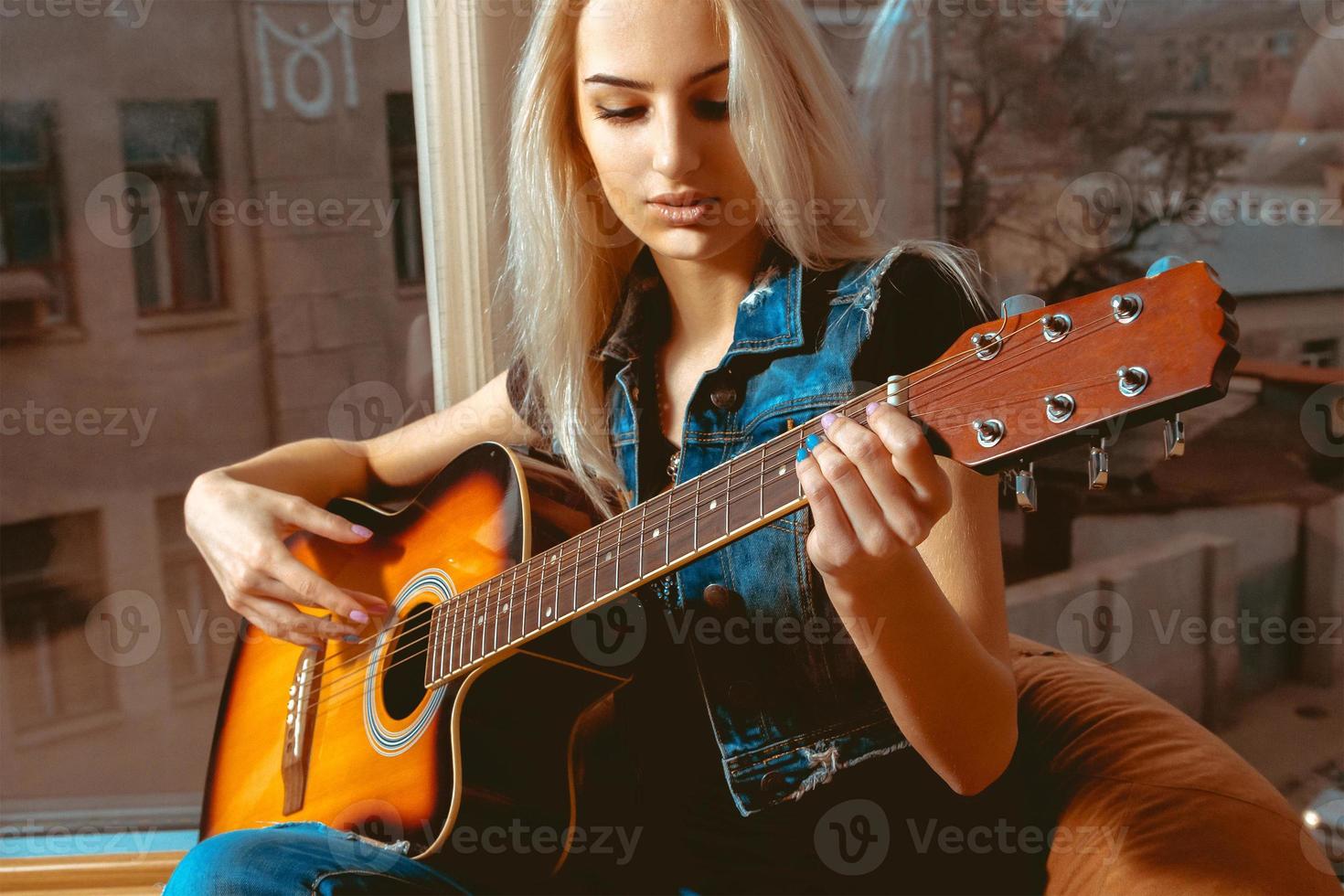 Closeup photo of beautiful woman with guitar in her hands
