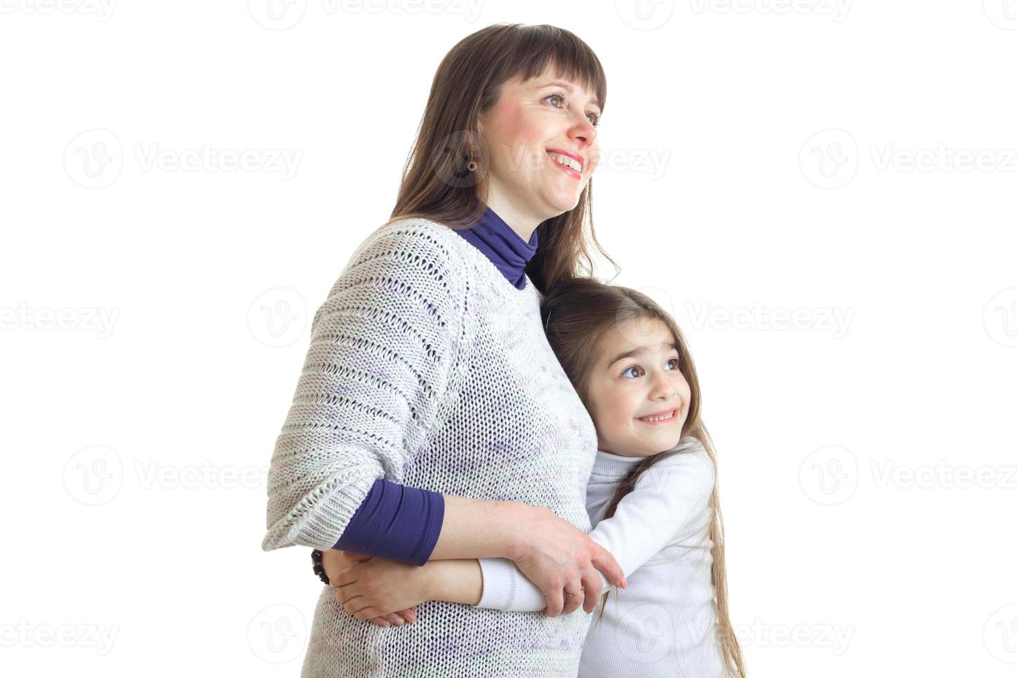 Cheerful mother hugs with little daughter and smiles photo