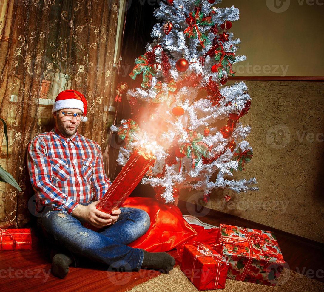 Square portrait of happy nerd with a lot of christmas presents photo