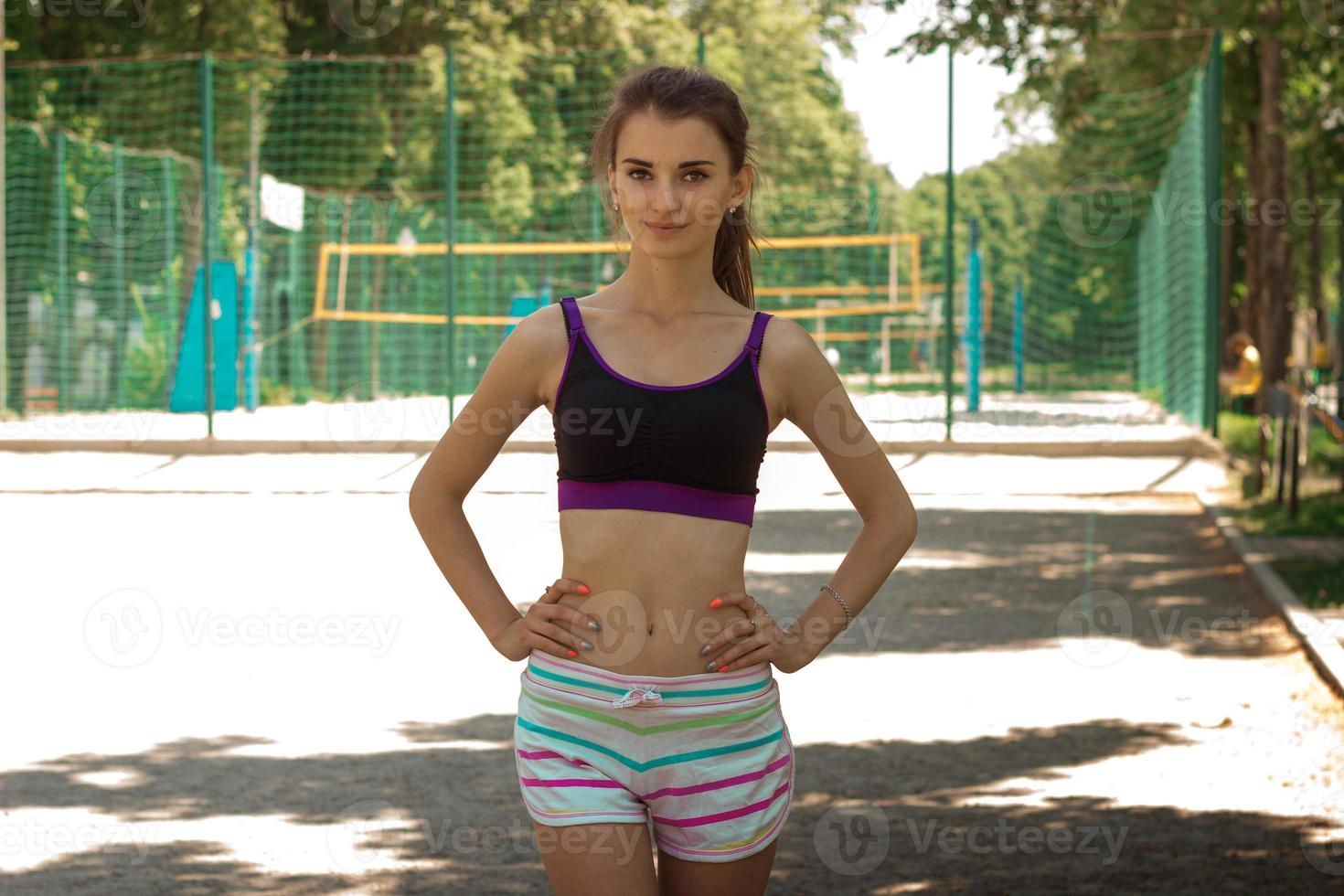 young slender fitness woman stands on the street and posing