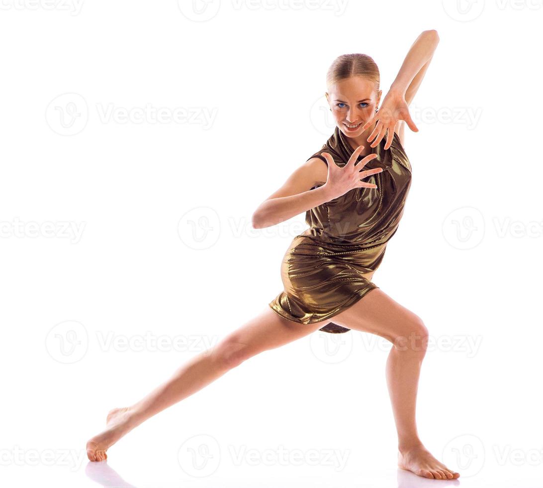 Ballerina in gold dress posing on white background photo