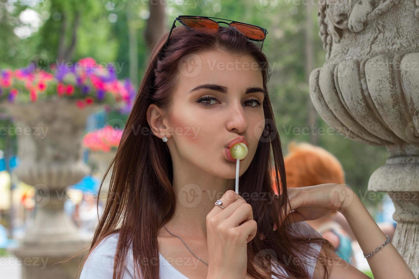 a close-up portrait of young sexual woman with lollipop photo