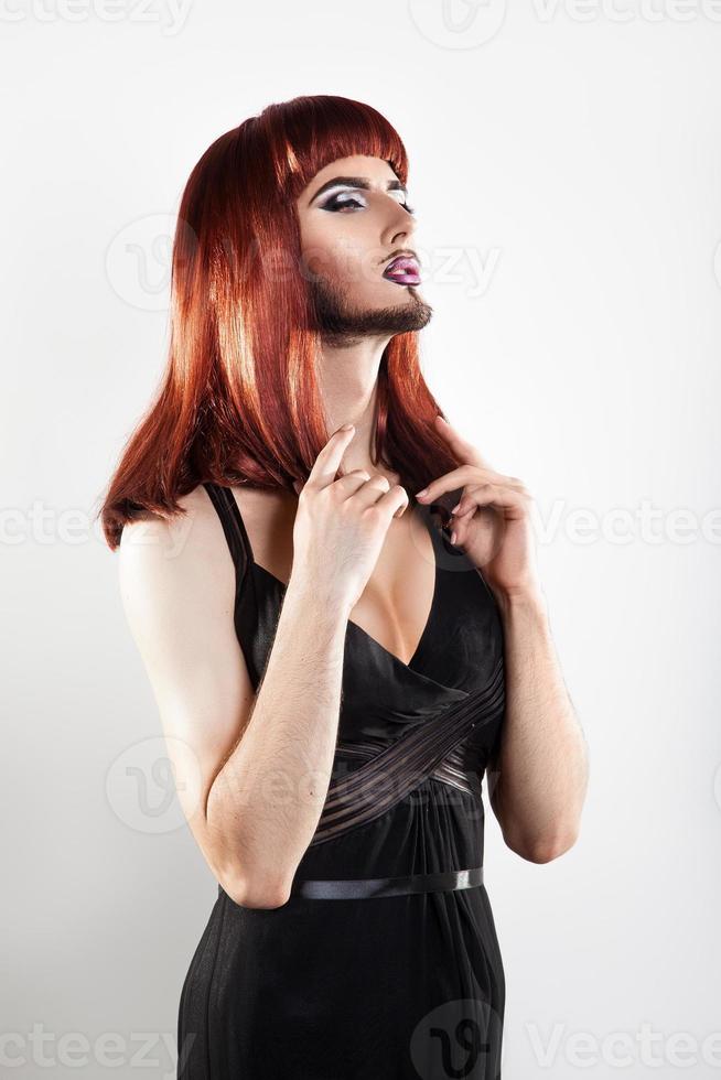 Tender redhair shemale with makeup and beard looking away photo