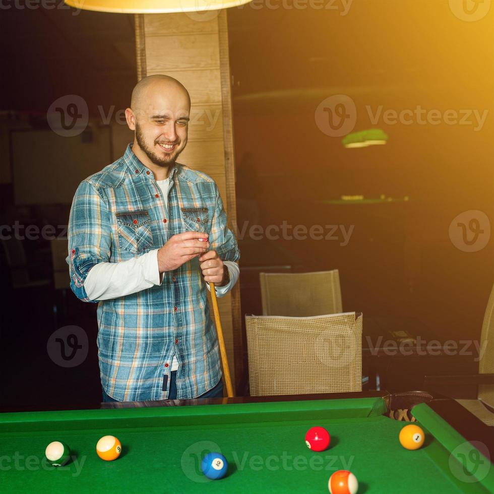 smiling handsome guy rubs cue chalk photo