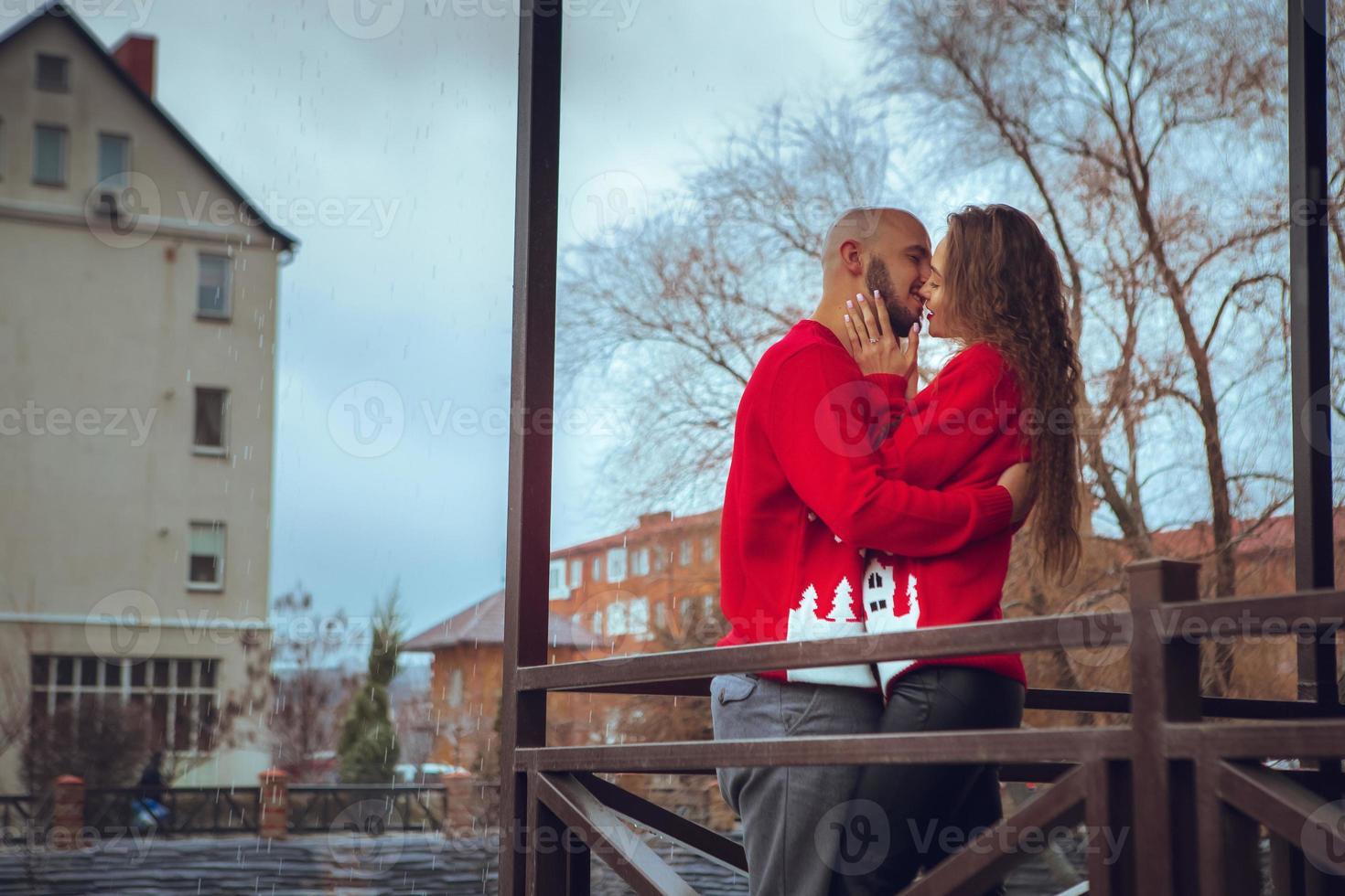 encantadora pareja apasionada se abraza en un balcón en invierno foto