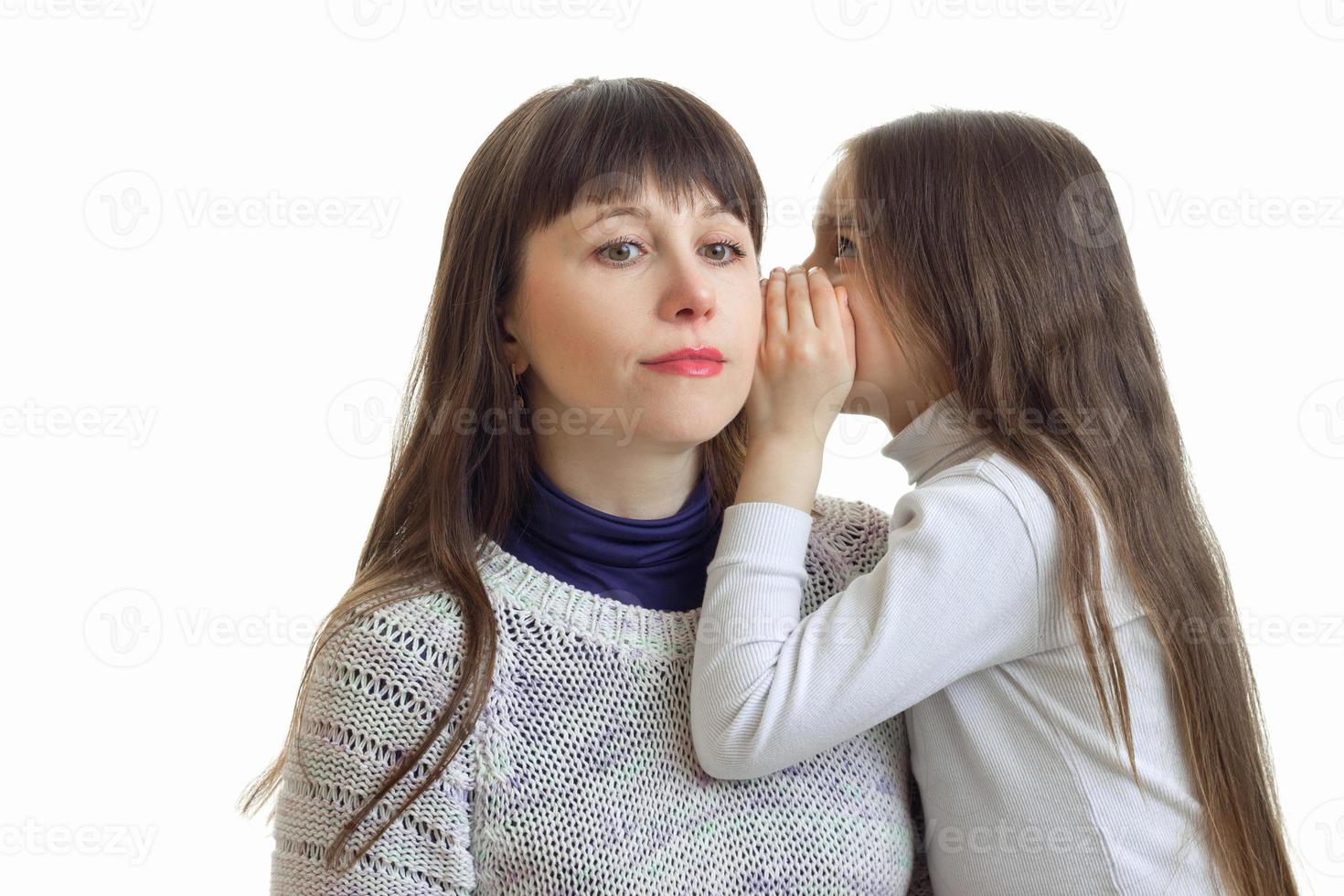 the little girl says something to her mother's ear close-up photo