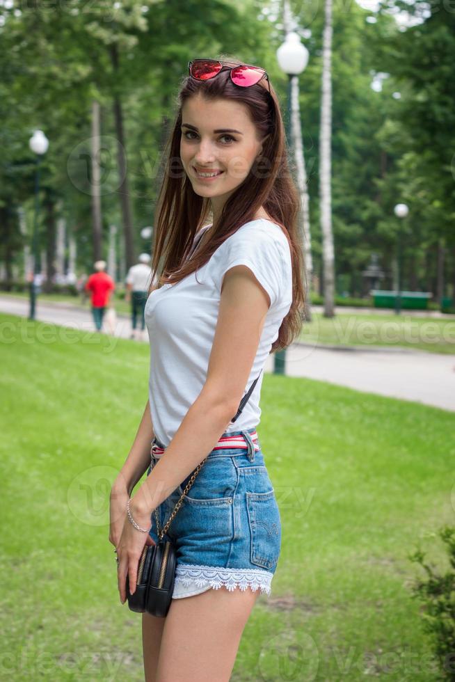 Cheerful young girl smiles on camera in the park photo