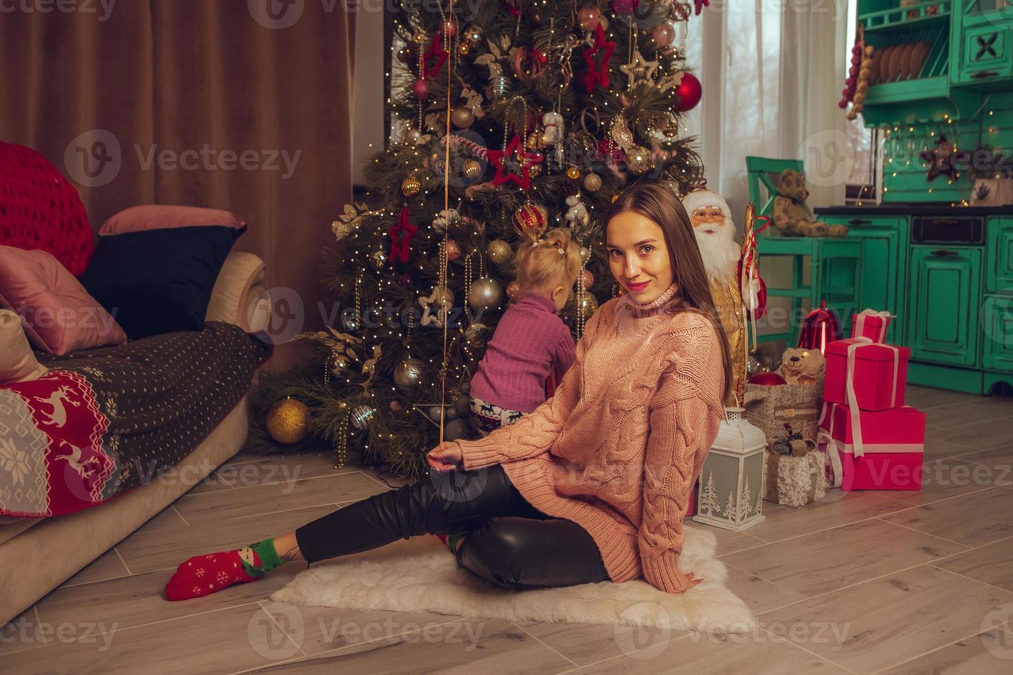 charming mother and daughter at the christmas tree photo