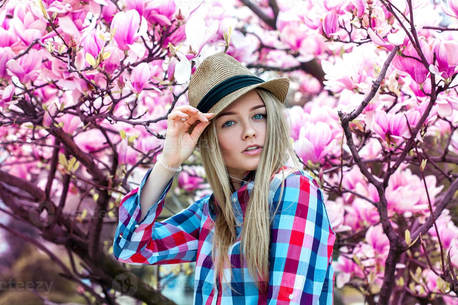 retrato de primavera de una linda joven rubia con sombrero con flores foto