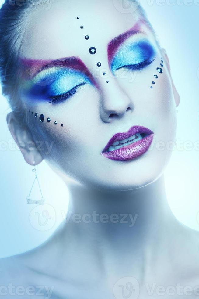 Vertical portrait of cutie woman with multicolor make up in studio photo