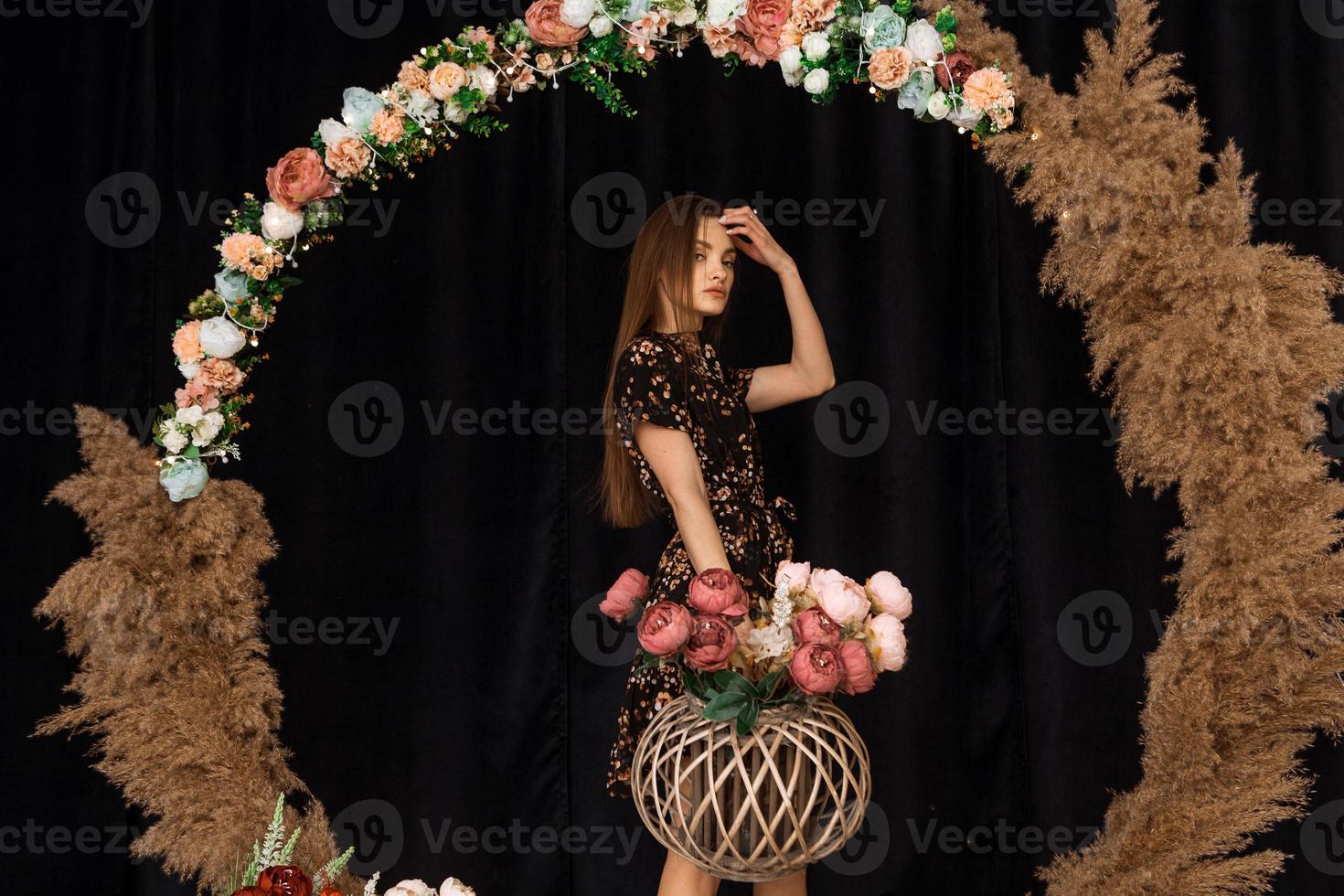 Beautiful woman posing at circle of deadwood in dress with flower print photo