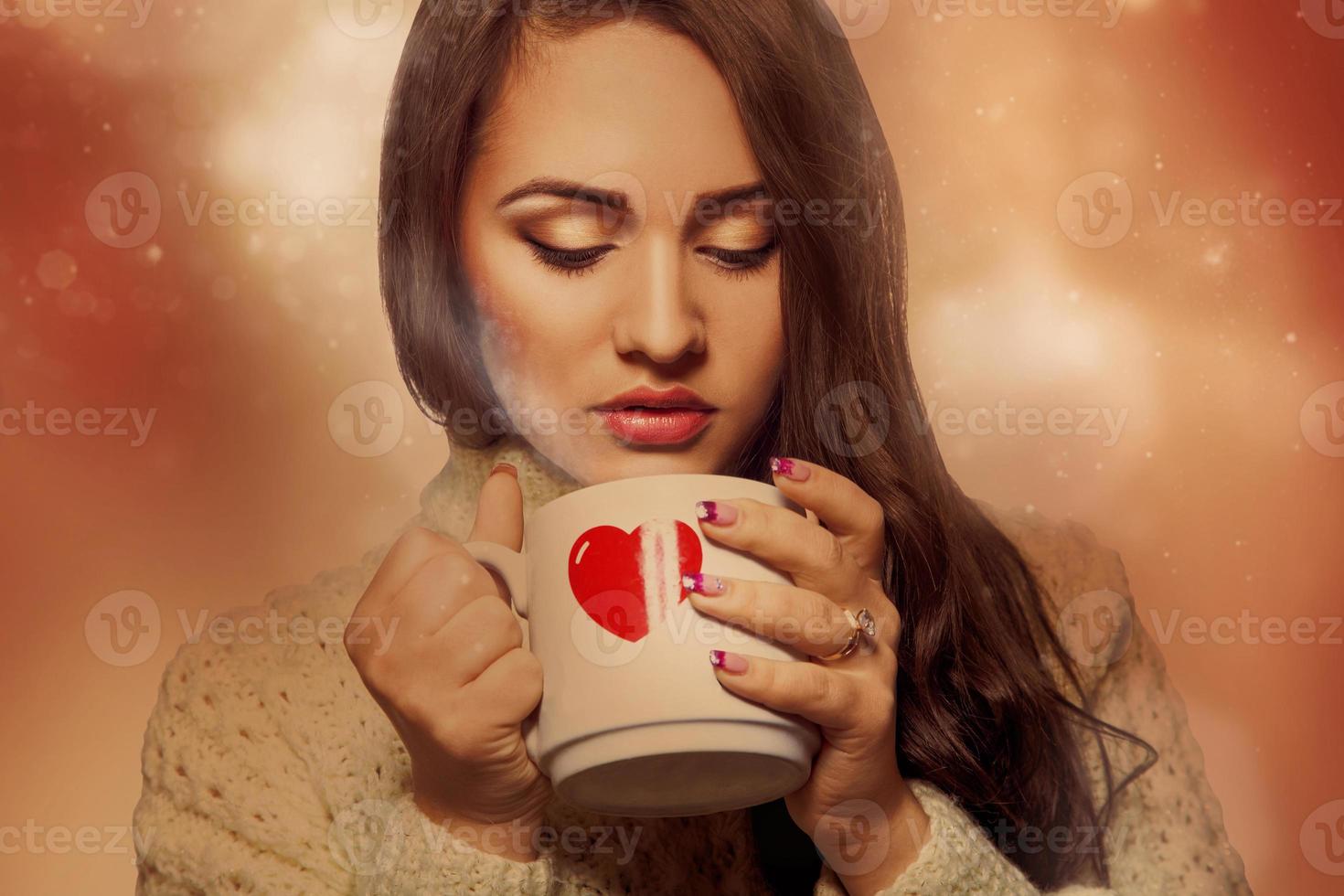 Voluptuous young brunette with hot drink in cup photo