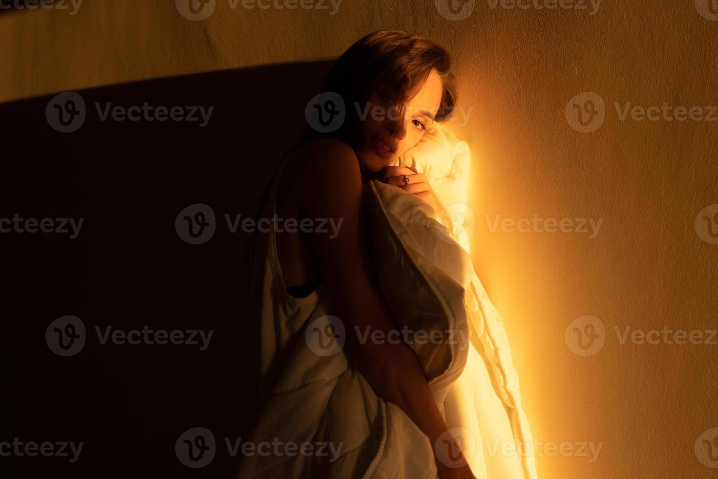 young girl in looking into the camera in the warm rays of sunset photo