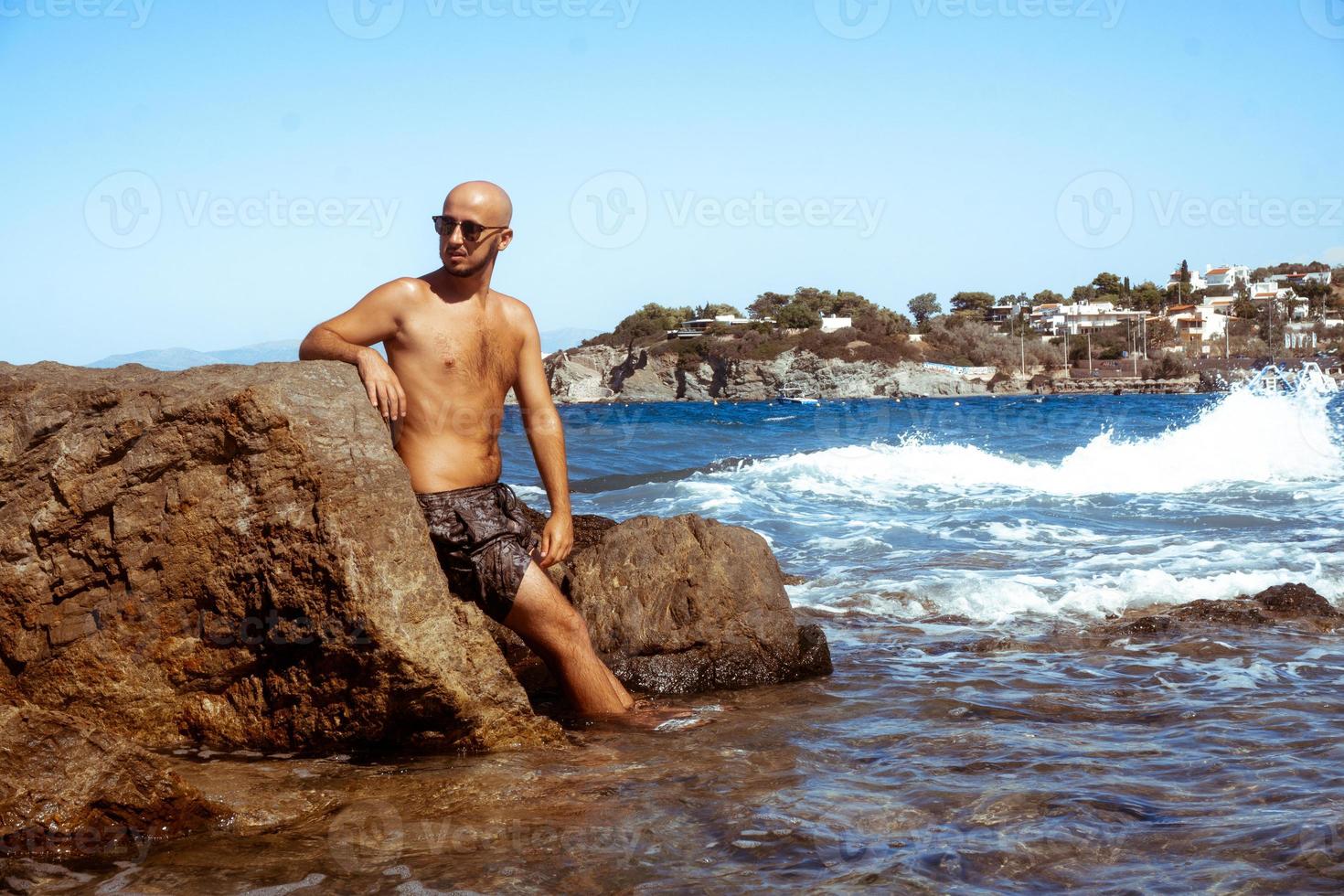 handsome man on the marine rocky shore photo