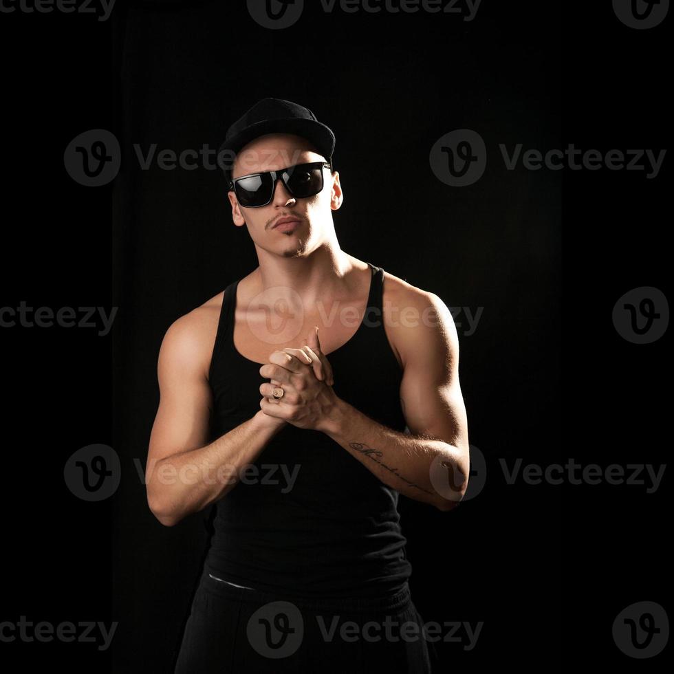 square picture of artist in sunglasses and shirt on black background photo