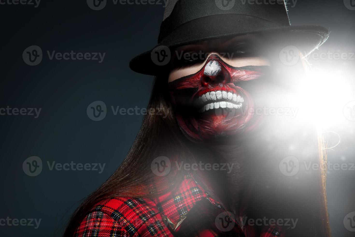 Adult woman with scary face art for halloween night looking at camera photo