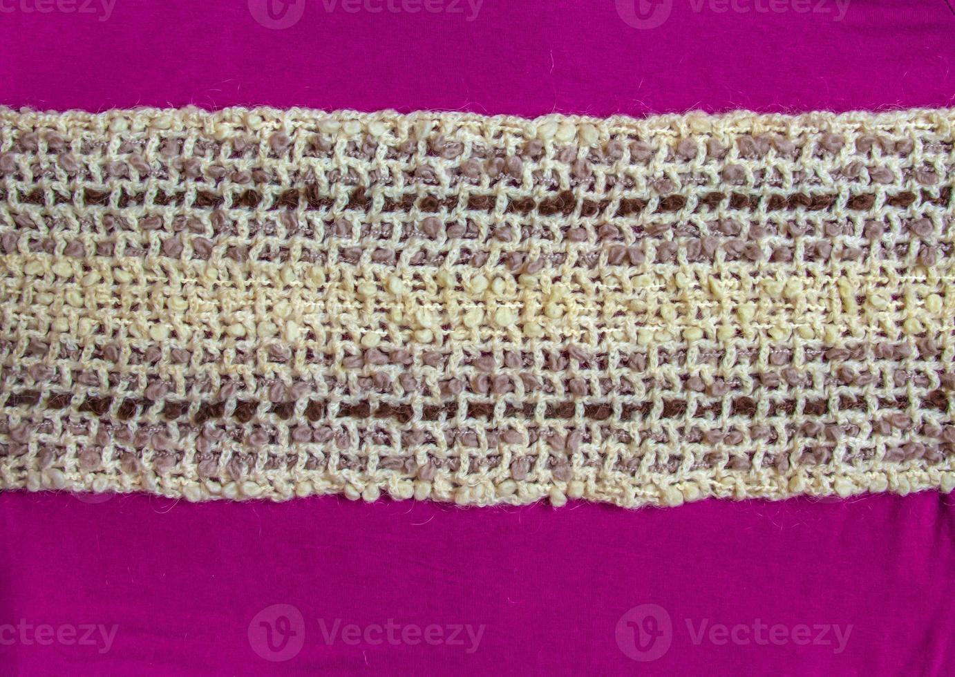 Warm beige woolen scarf on a lilac-burgundy background photo