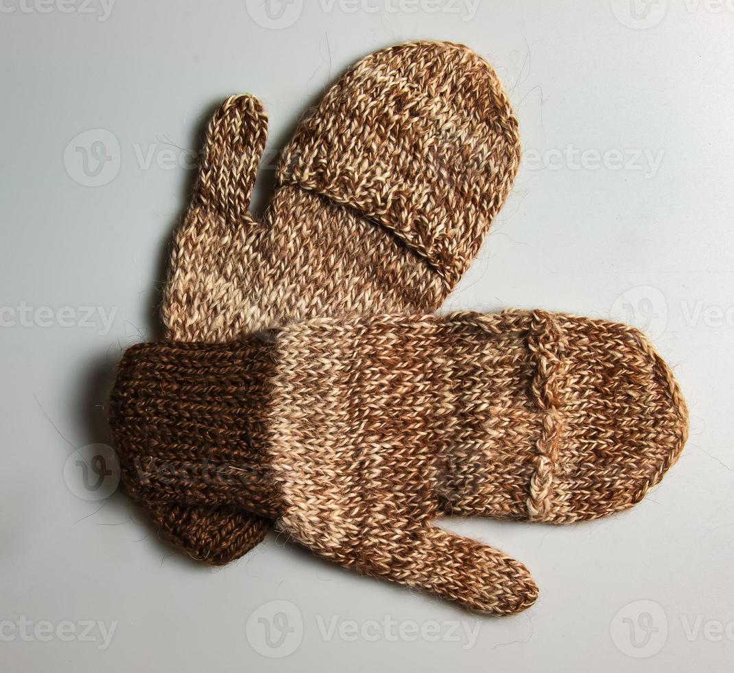 Handmade brown-beige mittens from Argentinean merino wool on a white background. photo