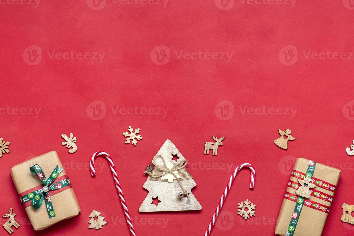 Handmade wrapped red, green gift boxes decorated with ribbons, snowflakes and numbers, Christmas decorations and decor on red table Xmas advent calendar concept Top view Flat lay Holiday card photo
