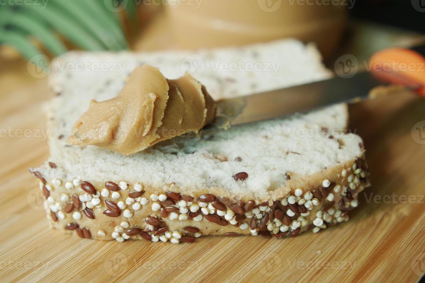 top view of peanut butter and a bread on plate on black background photo