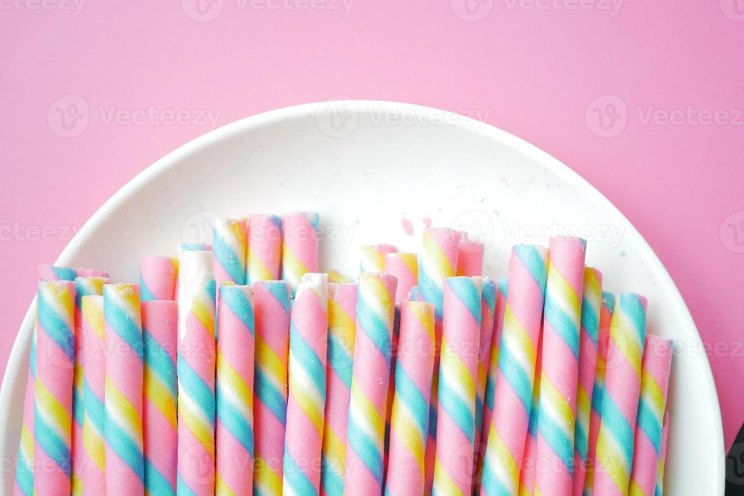 colorful wafer roll chocolate on pink background photo