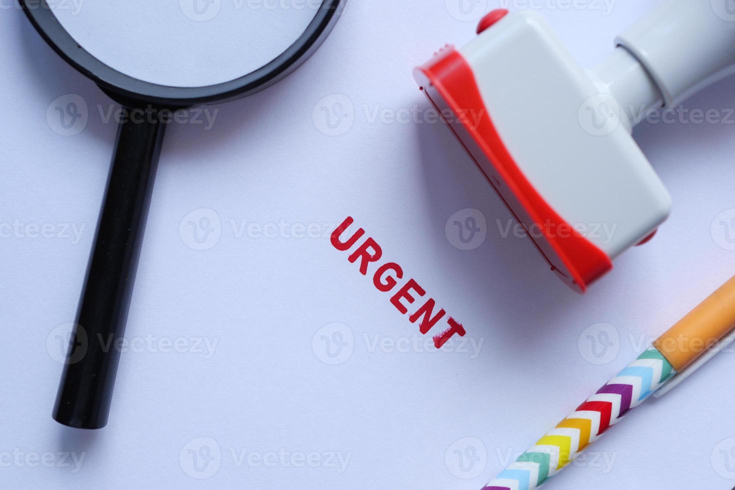 Red URGENT word stamp on a white paper photo