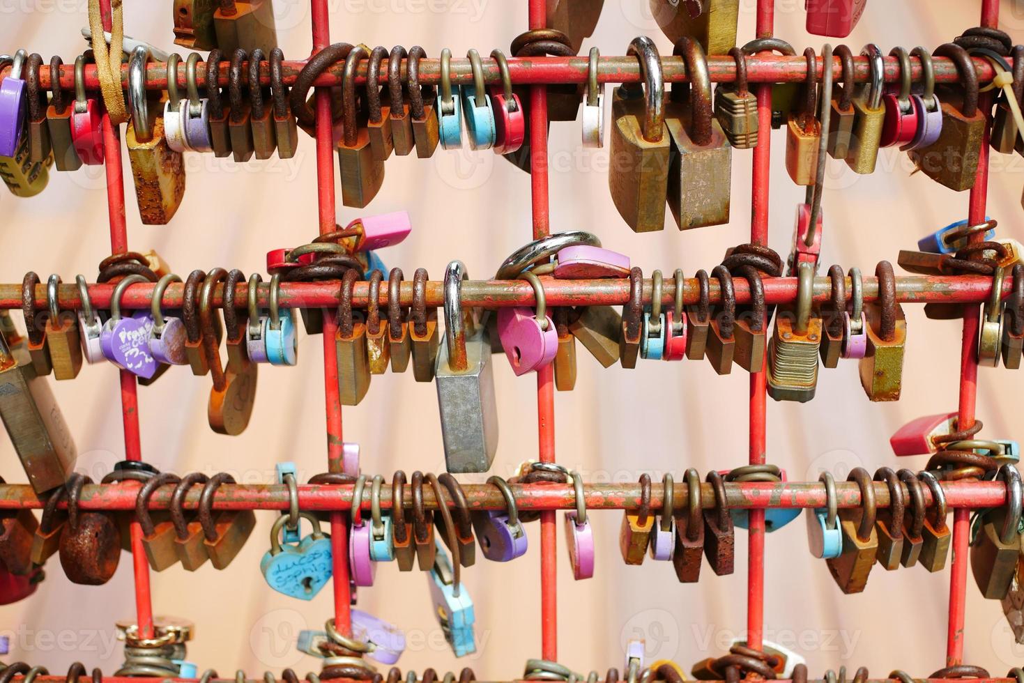 Many love padlocks locked on rusty iron gate in singapore photo