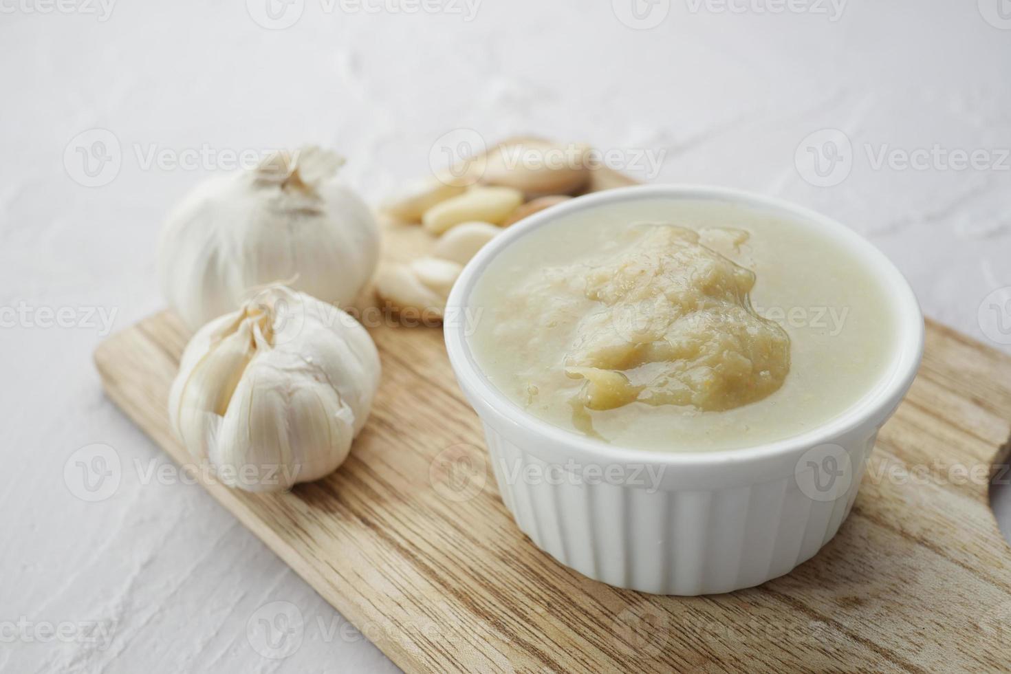 close up pf garlic paste in a container on table photo